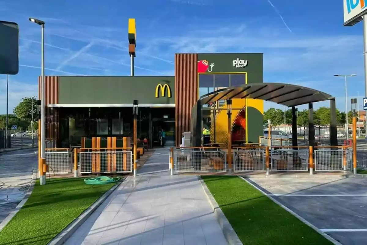 Un restaurante de comida rápida con un área de juegos al aire libre y un diseño moderno.