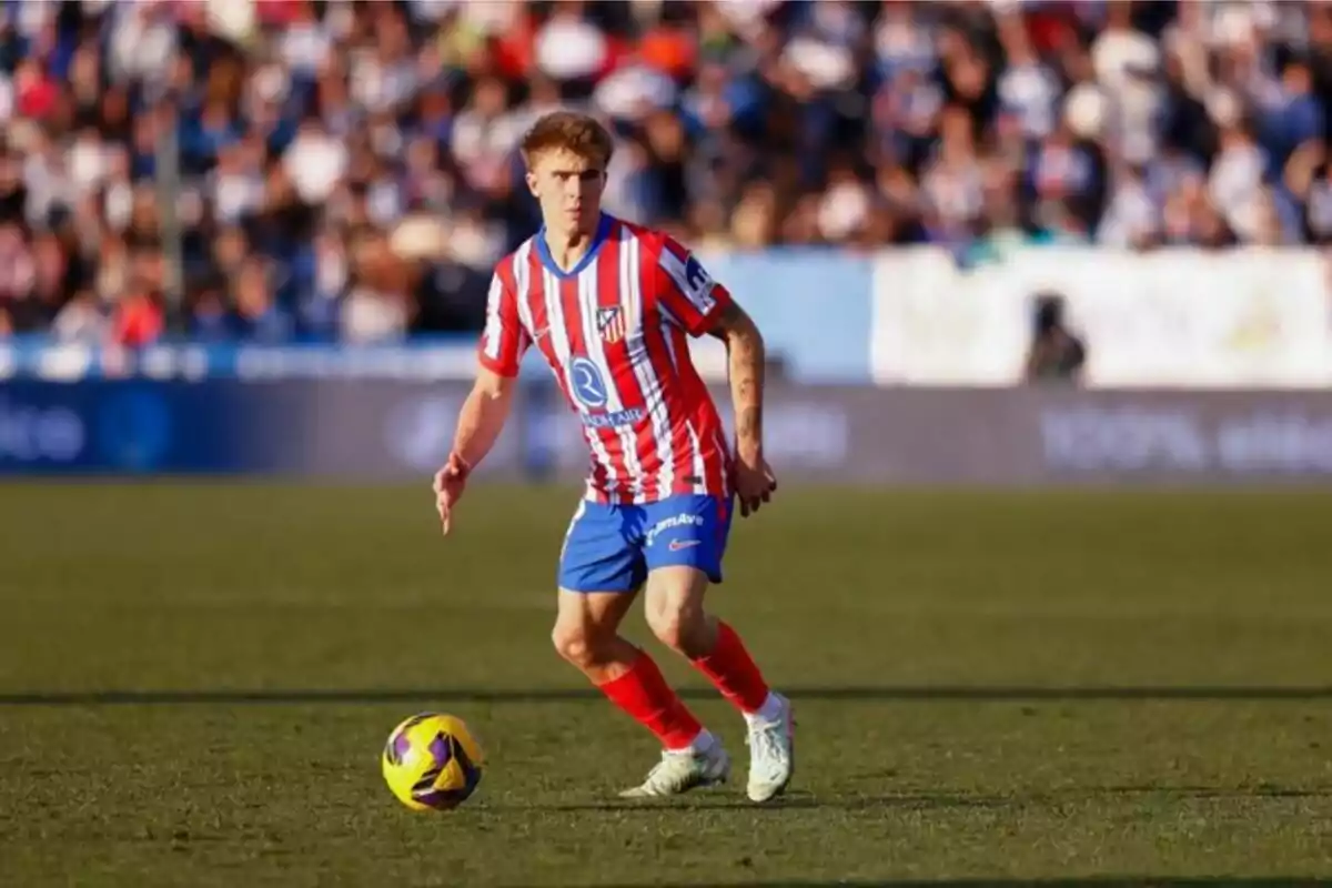 Un jugador de fútbol con uniforme rojo y blanco en el campo durante un partido.