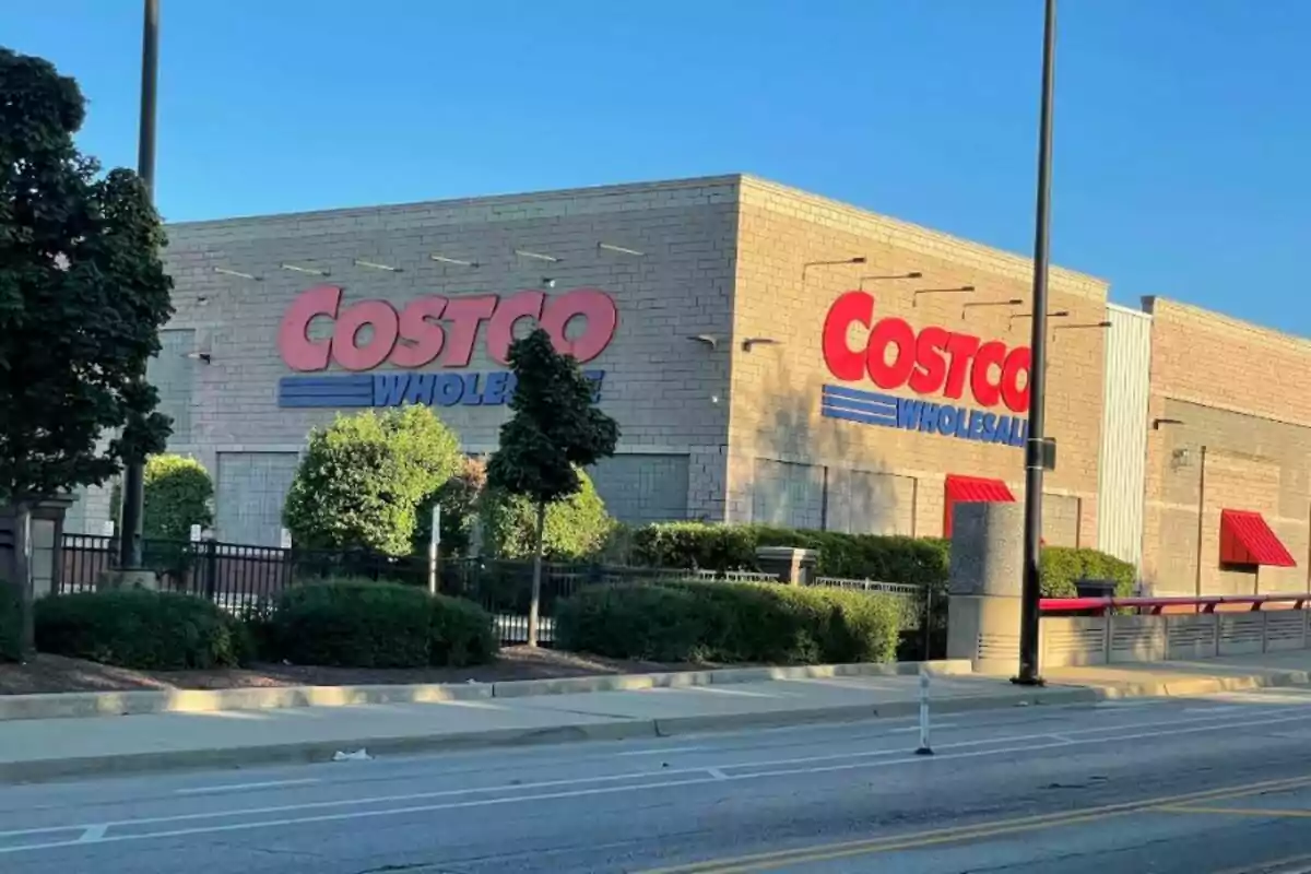 Fachada de una tienda Costco Wholesale con letreros grandes y arbustos al frente en un día soleado